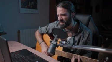Young masculine songwriter performing a concert in a live streaming in his home - Handheld motion close up shot