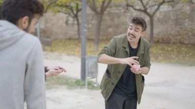 Sihirbazın sokaktaki kişiye kart numarası göstermesini yakından çek. Sokak göstericisi, sihirbaz bir sürü insana numaralar gösteriyor, şehir merkezinde. - 4K Yatay Görüntü