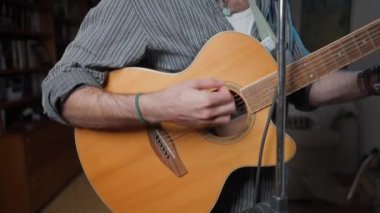 Musician playing the guitar at his home studio - Close up shot