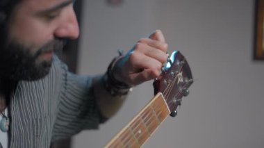 Yakışıklı gitarist çevrimiçi dinleyicilerine gitar akort etmeyi anlatıyor.