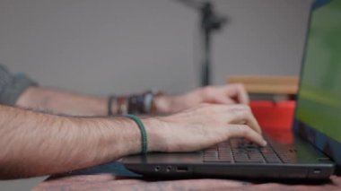 Kıllı eller yeşil ekranlı bir bilgisayarda yazı yazıyor.