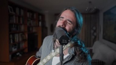 Young bearded vocal coach teaching how to sing online to his audience - Close up to wide shot