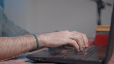 Young smiling musician talking online with his youtube audience using a laptop - Close up shot
