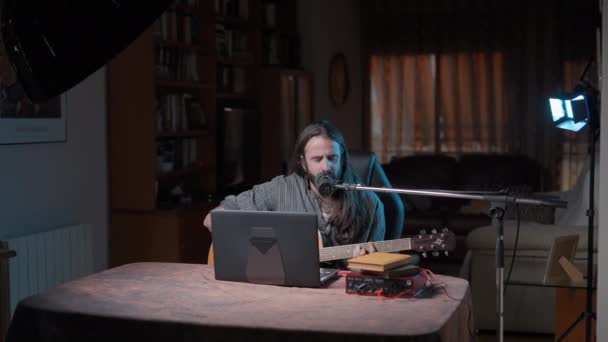Young Bearded Long Haired Musician Playing Guitar Singing Online His — Vídeos de Stock