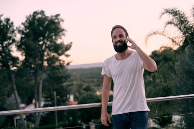 Genç ve yakışıklı bir adam, evinde yürürken eğlenceli bir telefon görüşmesi yaptığı için heyecanlıydı.