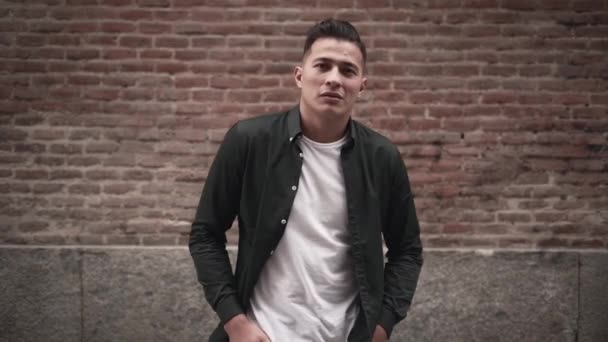 Hispanic Young Man Looking Camera Posing Hands Pockets Front Brick — Stock Video