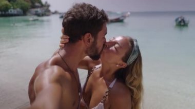 A close up shot of a couple kissing each other while standing on a beautiful beach. Romantic video - 4K Horizontal video