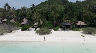 An aerial view of a beautiful loving couple walks on the seashore. Happy young couple spend time on the beach. - 4K Horizontal video