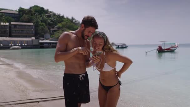 Static Shot Young Couple Looking Smartphone While Standing Beach Sunny — Wideo stockowe