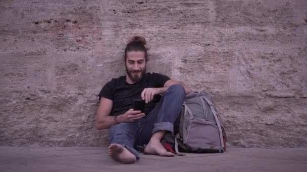 Backpacker Dirty Feet Using His Phone While Sitting Front Stone — Vídeo de stock