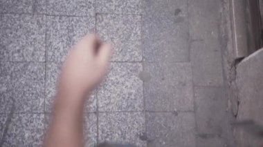 Point of view of young backpacker feet walking over city tiles barefoot - Horizonal video