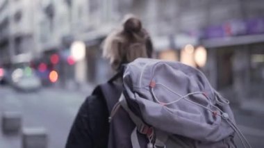 Follow shot of young backpacker playing around the city and having fun - Horizonal video