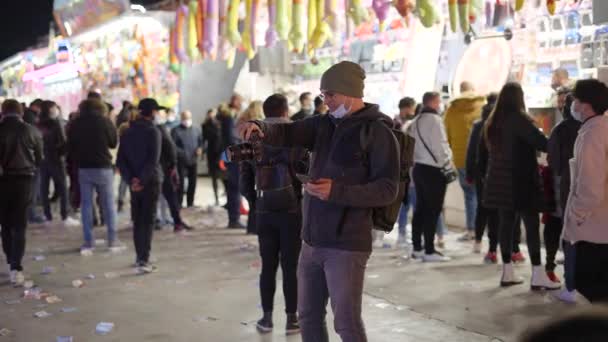 Фотограф Маске Фотографирует Ночью Ярмарке Валенсии Толпой Людей Идущих Заднем — стоковое видео