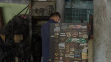 Male Mechanic Looking For Auto Spare Part Inside The Cabinet At The Workshop. medium shot - 4K Horizontal video