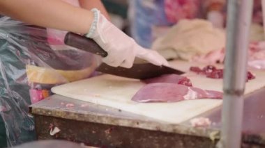 Close-up of professional fishmonger hands slicing fish with big sharp knife - 4K Horizontal video