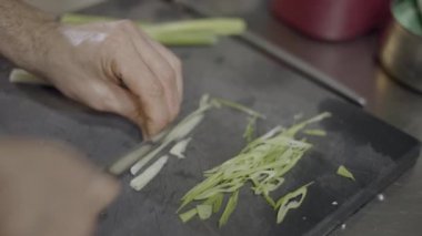Close-up of male chef hands slicing vegetables on cutting board - 4K Horizontal video