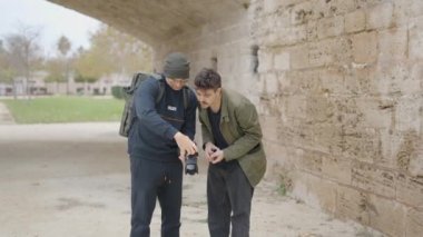 Friendship - two friends looking at photos in camera. - 4K Horizontal video