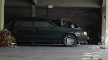 Mechanic With Flashlight Checking On Automobile Engine At Automotive Repair Shop. wide - 4K Horizontal video