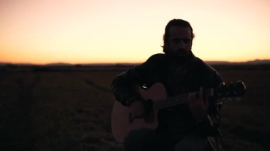 Spanish singer performing in front of beautiful sunset - Horizontal video
