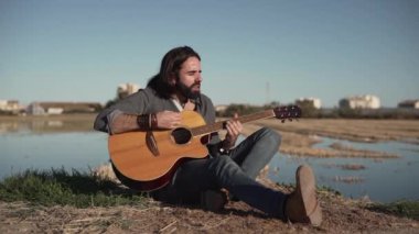 Inspired man playing the guitar and singing in spanish rural area in Valencia - Horizontal video