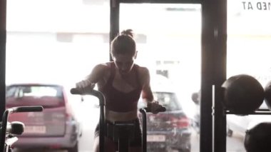 Athletic woman working out hard in static bike. Vigorous training. - Horizontal video