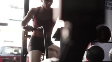 Exhausted looking woman using strength bike in workout morning session - Horizontal video