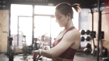 Female athlete using fitness smart watch to check results tracker after workout - Horizontal video