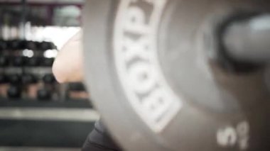 Strong young woman training in power lift session using barbell - Horizontal video