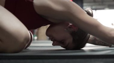 Close up of young woman in childs pose at the gym - Horizontal video