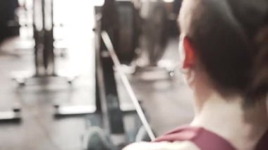 Fitness woman using rowing machine at the gym. Close up shot. - Horizontal video
