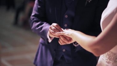Bridegroom exchanging wedding ring with bride - Horizontal Video