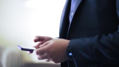 Man in elegant suit using his phone close up - Horizontal Video