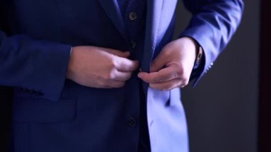 Groom buttoning up his jacket before the wedding ceremony - Horizontal Video