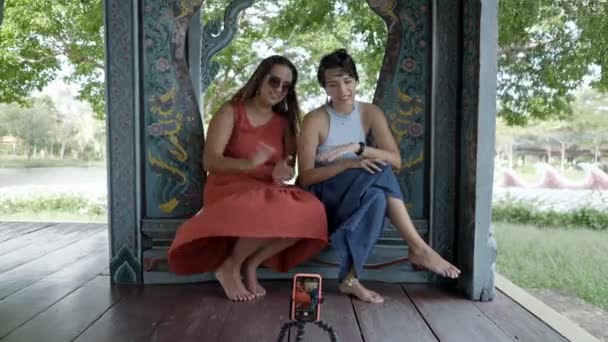 Two Girl Friends Tourists Making Video Blog Sitting Carved Wood — Video Stock
