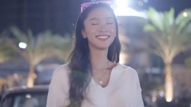 A happy cheerful girl wearing her white dress rejoicing and looking at camera with joyful and charming smile. - 4K Horizontal video
