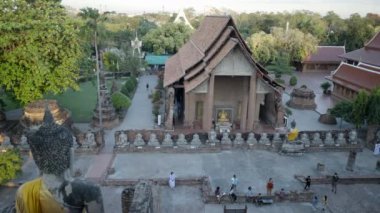 Top view of Wat Yai Chai Mongkhon Buddhist temple with travelers in Ayutthaya, Thailand - 4K Horizontal