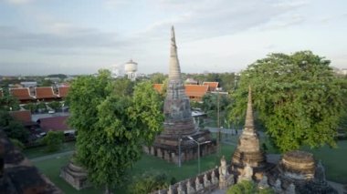 Panoramic shot from top revealing numerous ancient pagoda buildings of Wat Yai Chai Mongkhon temple in Ayutthaya, Thailand - 4K Horizontal