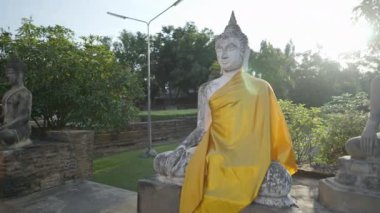 Row of Buddha Statues, Draped in Yellow Against Sun at Wat Yai Chai Mongkhon in Ayutthaya, Thailand - 4K Horizontal