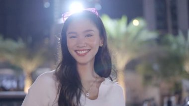 A beautiful girl is blushing and posing in front of camera and taking off her sunglasses to get a good picture. - 4K Horizontal video
