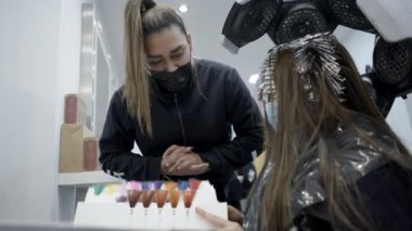 Stylist and customer discussing about color dye with catalog color - 4k Horizontal video