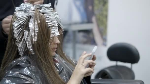 Young Woman Texting While Getting Highlights Salon Horizontal Video — Stock video