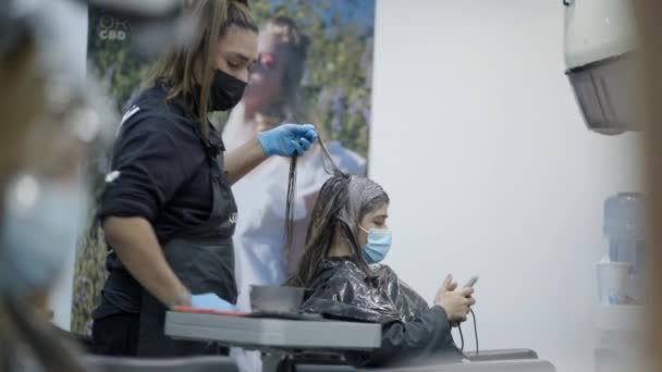 Male Gay Hairdresser Dying Hair Colombian Costumer While She Uses — Stock video