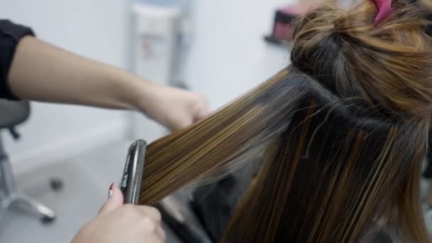 Close Unrecognizable Hairdresser Using Hair Straightener Clients Hair Horizontal Video — Stockvideo