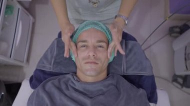 Man in his forties gets face massage at thai beauty salon - 4K Horizontal video