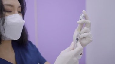 Close up of asian doctor extracting solution for face rejuvenation therapy - botox and collagen injections - 4K Horizontal video