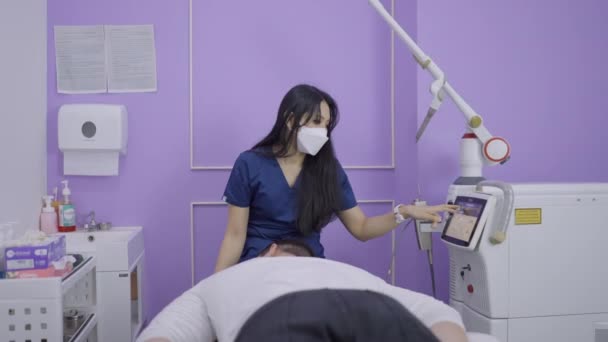 Cosmetologist Adjusting Laser Machine Beauty Procedure Thai Salon Horizontal Video — Vídeos de Stock