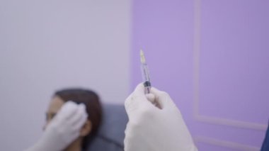 Patient with ice pack on her face to reduce pain from botox injections. Cosmetic procedure. - 4K Horizontal video