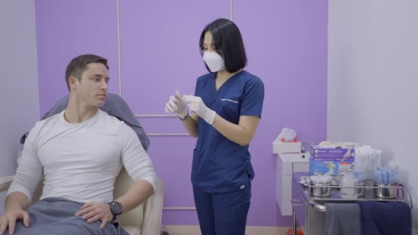 Asian Doctor Explains Cosmetic Procedure Caucasian Man Private Clinic Bangkok — ストック動画