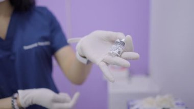 Female doctor shows botox and collagen vial to the camera and smiles - 4K Horizontal video