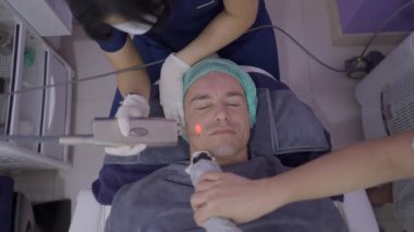 Doctor applies laser therapy on patients neck to remove wrinkles and imperfections - 4K Horizontal video